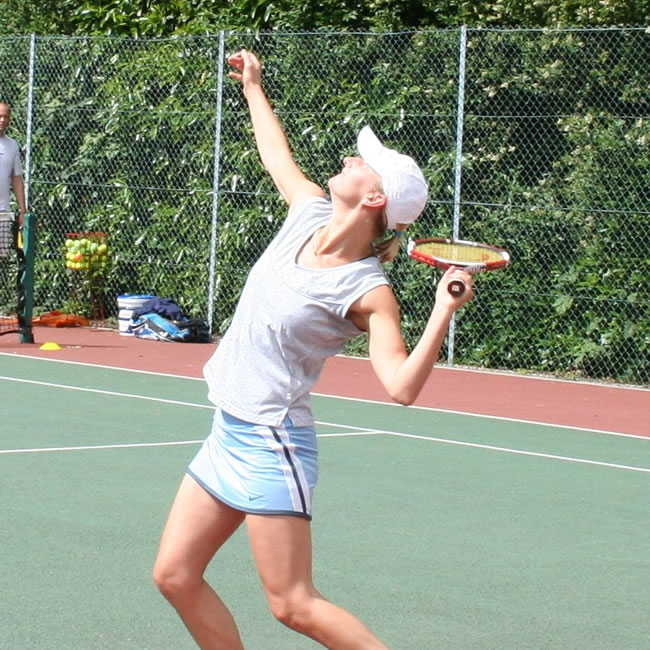 Lady serving in game at Wetybridge Lawn Tennis Club Walton Lane